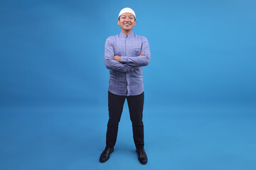 Full Body Of Young Asian Muslim Man Smiling And Standing Confidently Over Blue Background