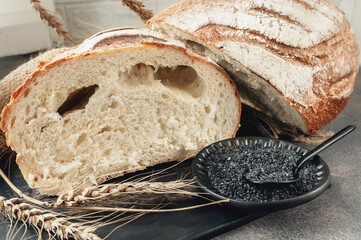 Freshly baked bread with a bowl of cream and a spoonful of rustic black volcanic salt
