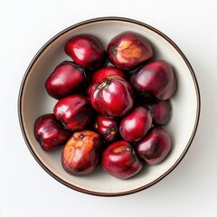Obraz premium Vivid Red Pomegranates in a Ceramic Bowl on a White Background