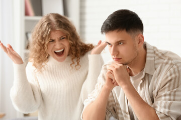 Screaming wife and thoughtful husband quarreling at home