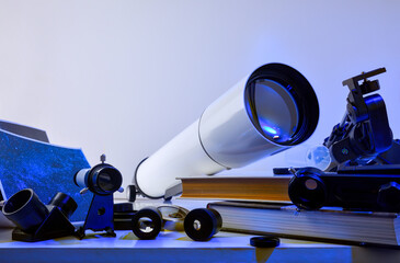 Equipment for astronomical study with telescope and parts on table