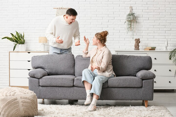 Fototapeta premium Young couple arguing in living room