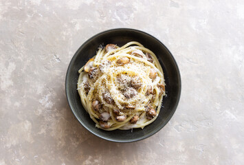 Bucatini pasta in creamy sauce with mushrooms and cheese. Vegetarian food. Italian cuisine.