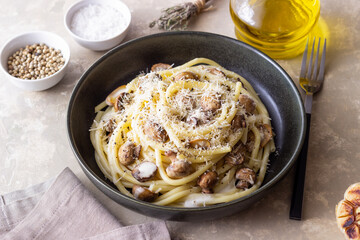 Bucatini pasta in creamy sauce with mushrooms and cheese. Vegetarian food. Italian cuisine.