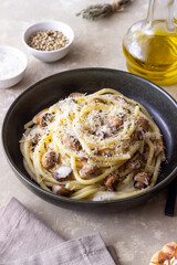 Bucatini pasta in creamy sauce with mushrooms and cheese. Vegetarian food. Italian cuisine.