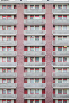 Facade of  a council housing block faced with panels in red colour in London