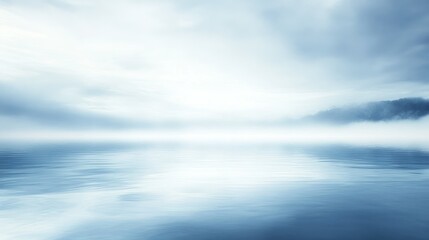 Obraz premium Serene water surface reflecting the foggy clouds and distant land
