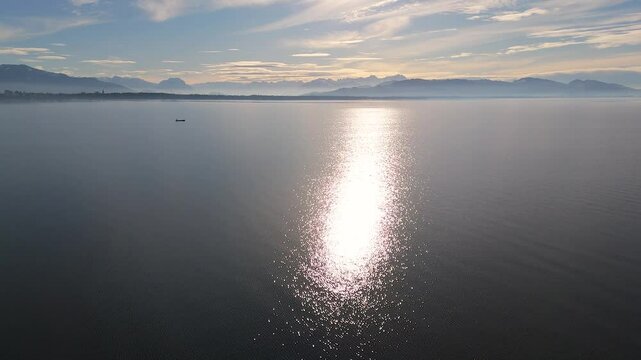 Bodensee - magische Winterstimmung mit sonnengl&auml;nzender Seefl&auml;che, Fischerboot und Blick in das Rheintal mit schneegl&auml;nzenden Alpengipfeln