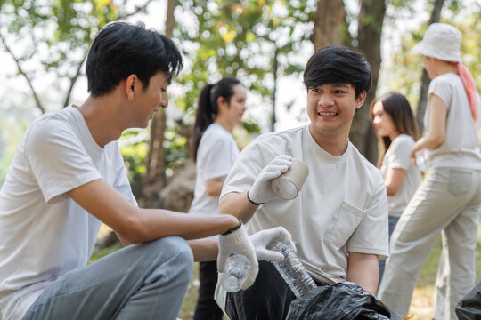 Two young men smiling while participating in a community cleanup event