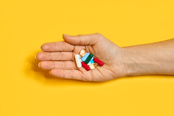 Various pills of different colors and shapes at hand