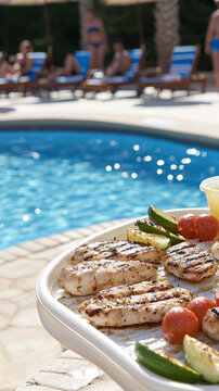 Grilled chicken and vegetables by the pool