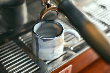 Close up of coffee machine pouring espresso in cafe