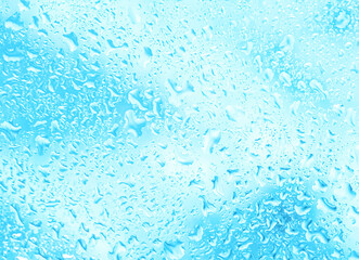 Abstract background with water drops on glass creating a blurred pattern on a light blue background. Soft pastel colors, blur effect, texture of drops. Creates a feeling of freshness and coolness.