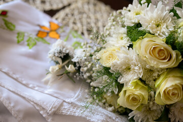 A bouquet of white and yellow flowers like Biedermeier on a table with antique tablecloths