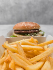 French fries and hamburger served in cardboard boxes on table galentines day
