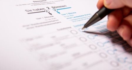 Obraz premium 12. February 2025 - Berlin, Germany. Close up of a female hand marking CDU party on a ballot paper with a pen