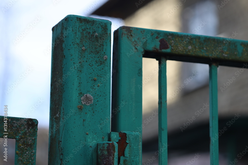 Aufkleber A close-up shot of a green gate with a building in the background.