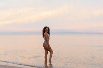 Young woman enjoying sunset at the beach during summer vacation