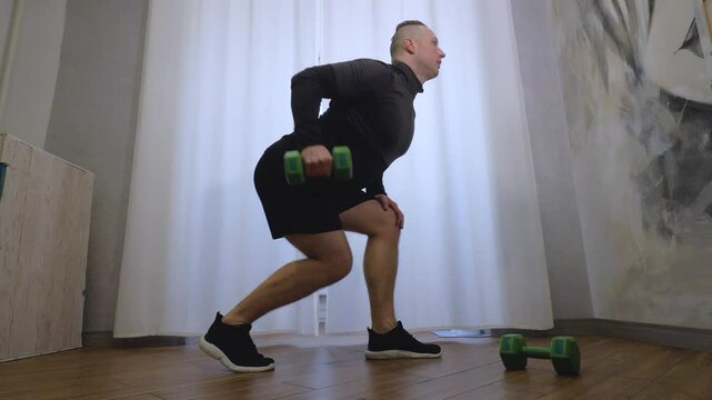 Men's back muscle training, swinging arms with dumbbells, workout at home, slow motion