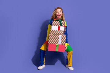Young woman in colorful outfit holding gift boxes against purple background, cheerful expression symbolizing holiday spirit