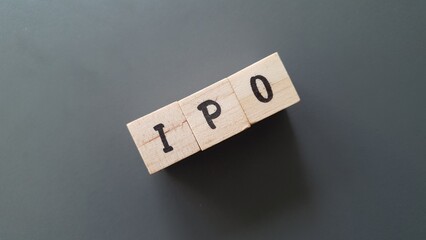 IPO acronym made of wooden letter cubes on dark background. Initial Public Offering