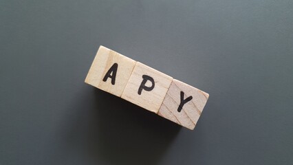 APY acronym made of wooden letter cubes on dark background. Annual Percentage Yield