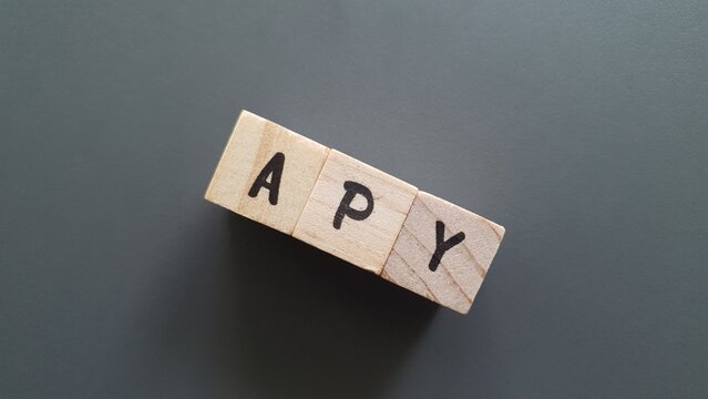 APY acronym made of wooden letter cubes on dark background. Annual Percentage Yield