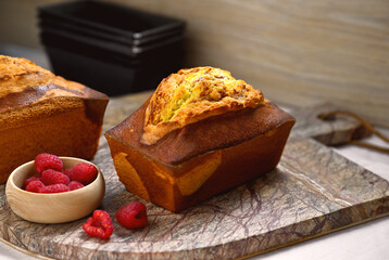 appétissant cake marbré aux framboises posé sur une planche à découper en marbre
