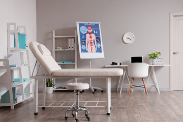 Interior of medical office with workplace, couch and shelf units