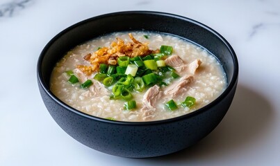 Delicious bowl of chicken porridge topped with green onions and crispy shallots, perfect for a comforting meal.