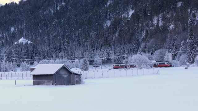 Passenger train crossing a winter landscape in Scharnitz, Austria