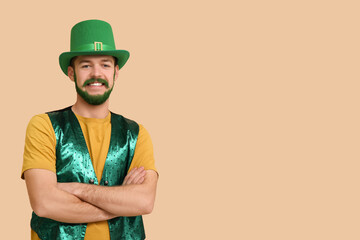 Young man in leprechaun hat with green beard on beige background. St. Patrick's Day celebration