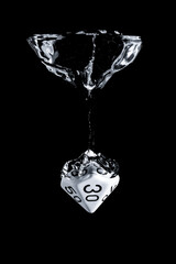 Splash photography of a 10 faces dice dropped in water with black background