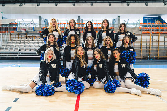 Cheerleaders Performing Dance Routine in Modern Sports Arena with Enthusiastic Spirit. High quality photo