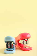 Different staplers on yellow background