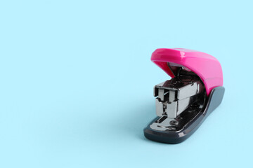 Pink stapler on blue background