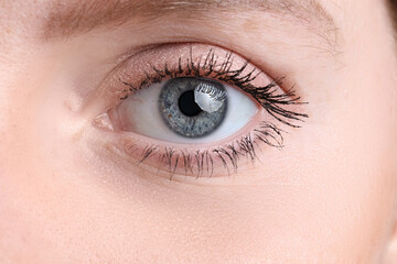 Obraz premium Young woman with beautiful blue eyes. Closeup