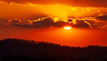 Dramatic sunset over mountain landscape. Beautiful landscape foggy hills twilight time. Blue golden sky sunrise dramatic beautiful landscape mountain. Dawn sky gold dusk time cloudscape with sunlight