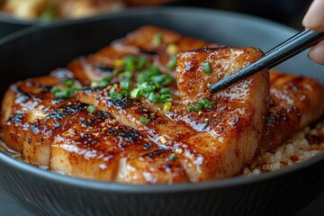 A person is using chopsticks to place chili powder on the meat in their bowl