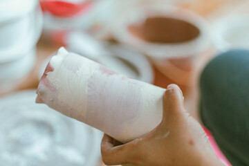 woman learning color painting her pottery
