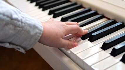Fototapeta premium Children's hands on piano keys