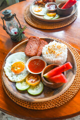 Delicious filipino breakfast with spam, rice, fried egg, and fruits in siargao island