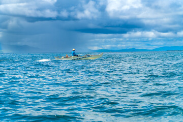 Filipino fisherman navigating the waters of siargao island, philippines
