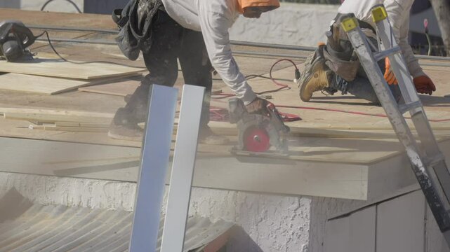 This video shows a roofer sawing through roofing material.