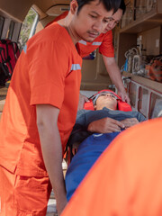Emergency medical worker in orange uniform providing first aid treatment and care