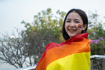 A joyful woman wrapped in a vibrant flag, celebrating her culture with pride against a backdrop of...