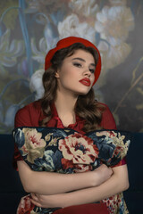 Portrait of a girl in a red beret with a pillow