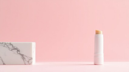 Hygienic lipstick alongside a marble board against a pink background, seen from above. Space for text.