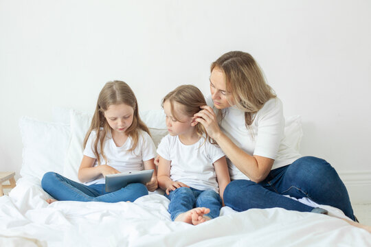 Happy family. Parents and their daughter having fun on a bed indoors
