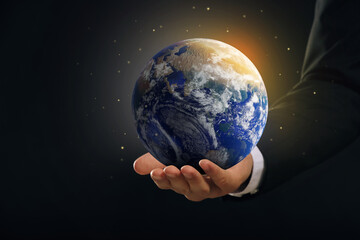 Planet in our hands. Man holding glowing Earth on dark background, closeup